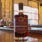 Five Saints Distilling Midnight Orchard Blackberry Plum Liqueur bottle on the bar inside the historic firehouse distillery, showcasing the small batch low-ABV dark fruit liqueur