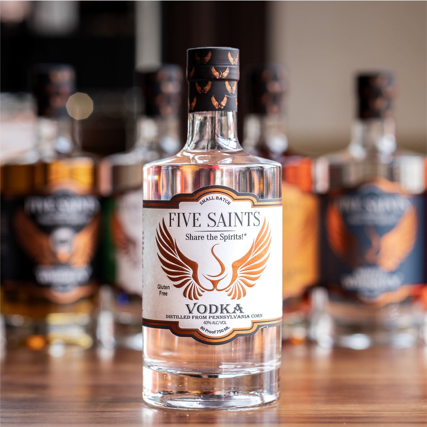 Five Saints Distilling Triple Slow Distilled Vodka bottle, a small batch gluten-free vodka made from Pennsylvania sweet corn, with other spirits bottles in the background