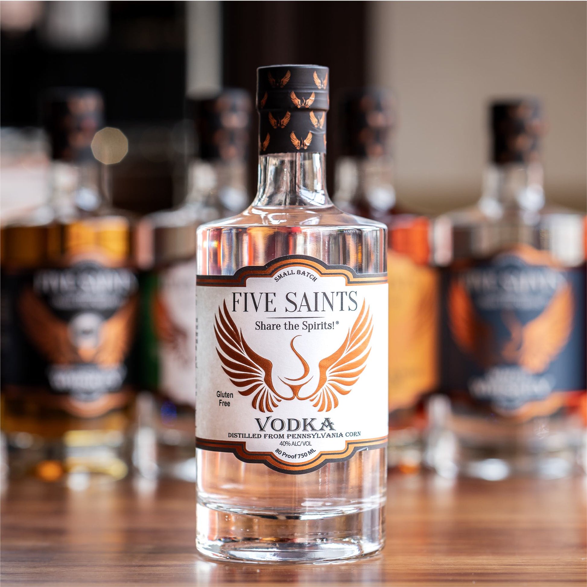 Five Saints Distilling Triple Slow Distilled Vodka bottle, a small batch gluten-free vodka made from Pennsylvania sweet corn, with other spirits bottles in the background