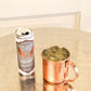 A can of Five Saints Rum Mule and a copper mule mug, set on a reflective metallic table